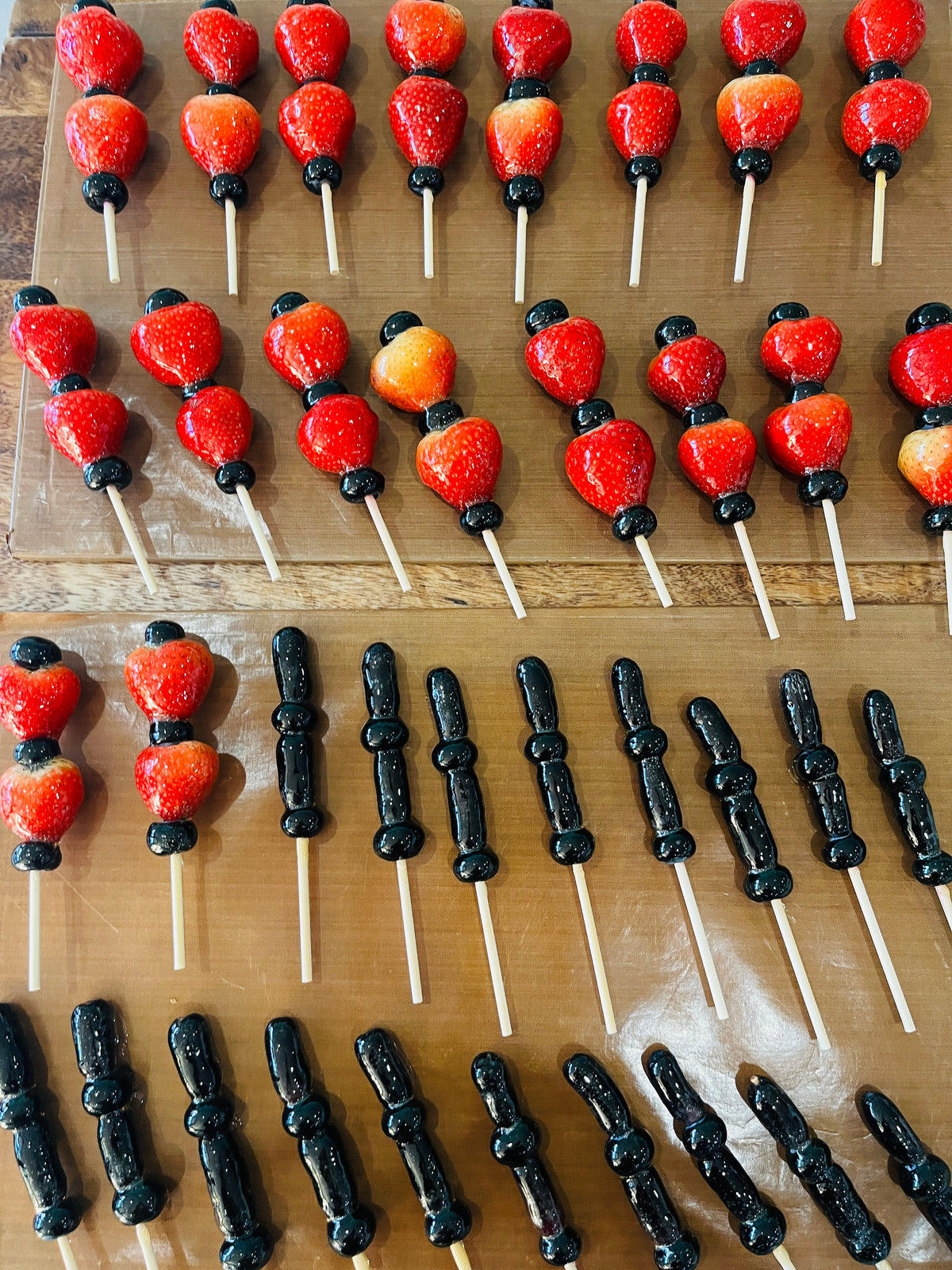 Freshly hand-glazed Vampire's Heart strawberry skewers and Witch's Finger grape skewers made by Olivia's Tanghulu