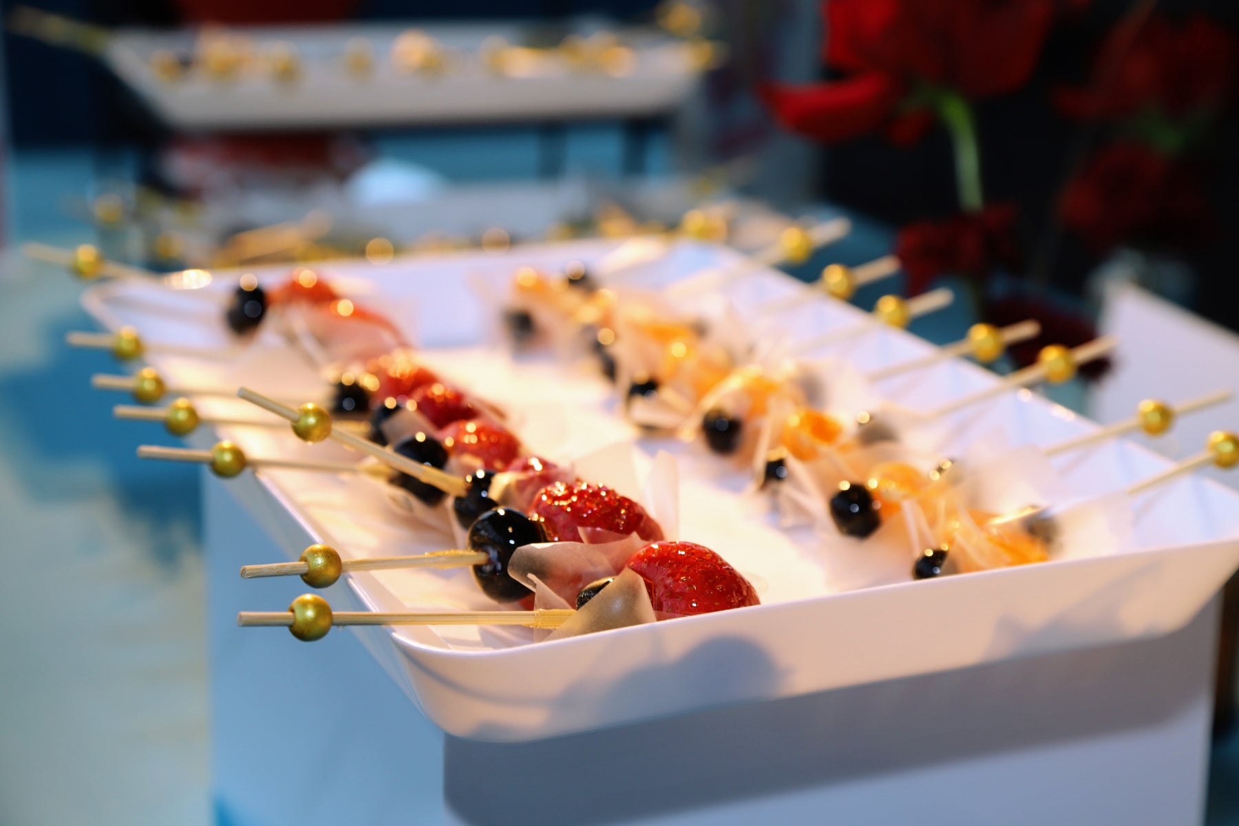 Elegant fresh fruit tanghulu skewers on gold-tipped picks at a Bay Area mitzvah celebration