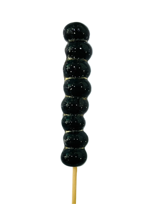 Sugar glazed blueberries on a stick against a light background