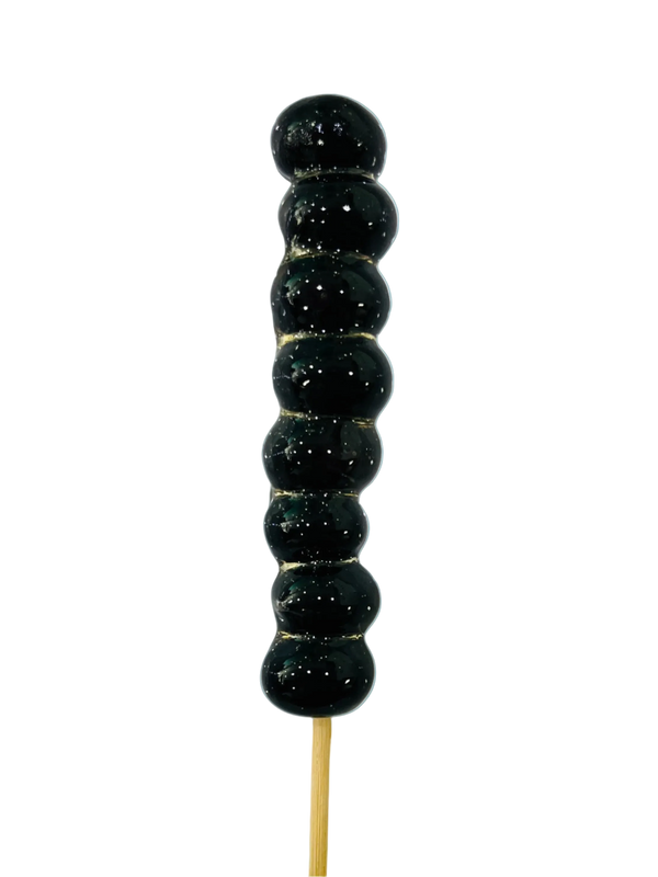 Sugar glazed blueberries on a stick against a light background