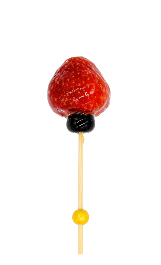 Glazed Strawberry tanghulu on a stick with a blueberry and cocktail pick. 