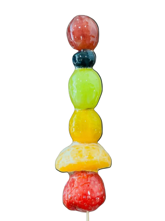 Sugar glazed Fruit skewer with colorful fruit pieces on a light blue background