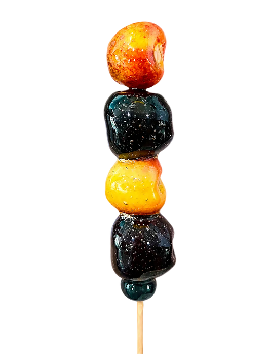 red and rainier cherries with a blueberry on wooden stick with crunchy sugar coating