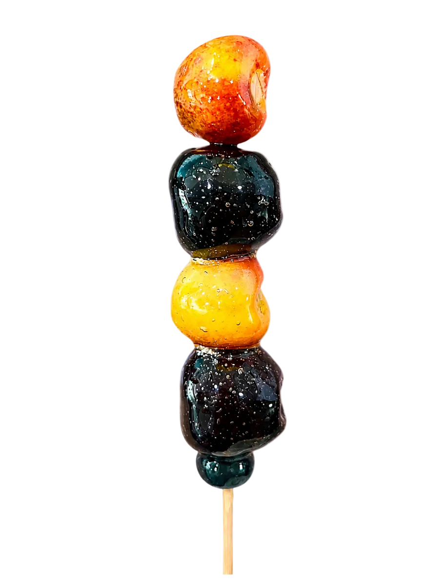 red and rainier cherries with a blueberry on wooden stick with crunchy sugar coating